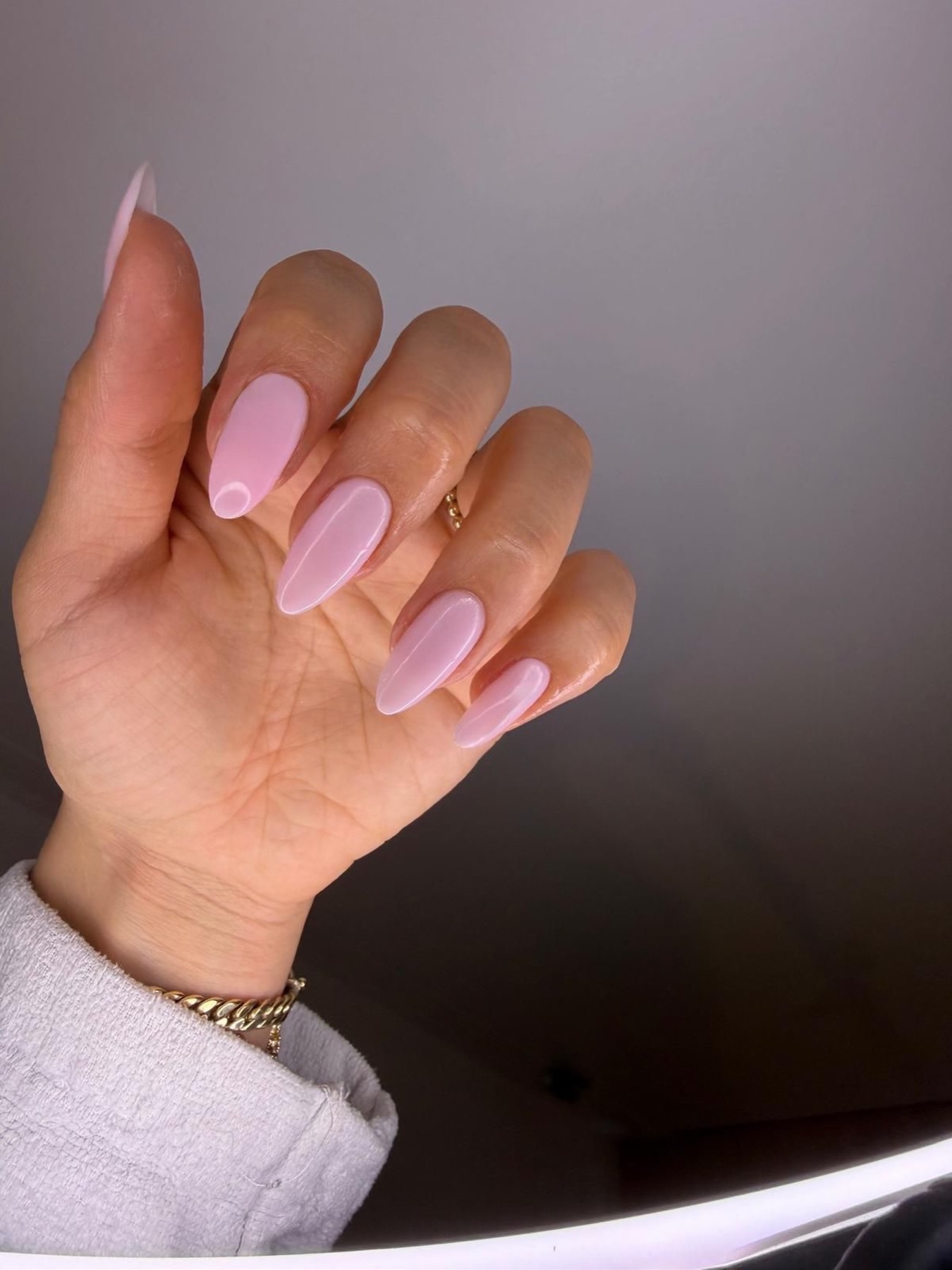 Hand mit rosa und fliederfarbenen Nägeln